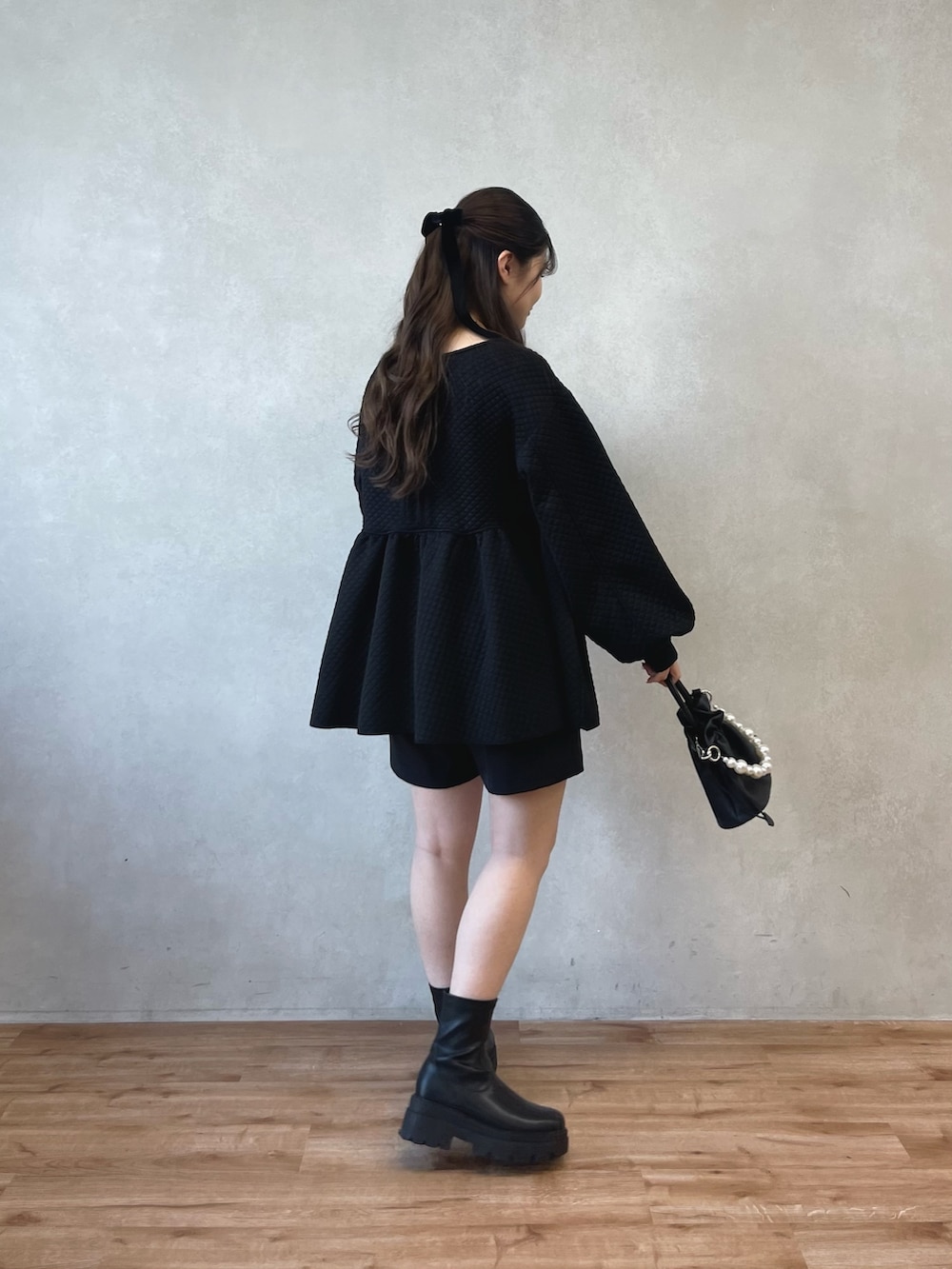 ブラック系のショルダーバッグ、ブラック系のブーツ、ブラック系のその他パンツを着用したレディースの春コーディネートの2枚目の写真