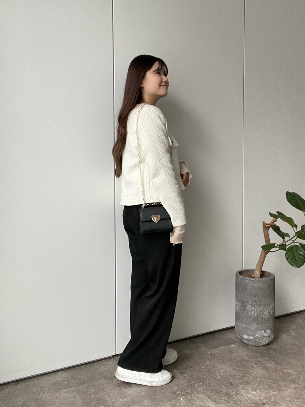 ホワイト系のTシャツ/カットソー、ホワイト系のノーカラージャケット、ブラック系のスラックスを着用したレディースの冬コーディネートの2枚目の写真