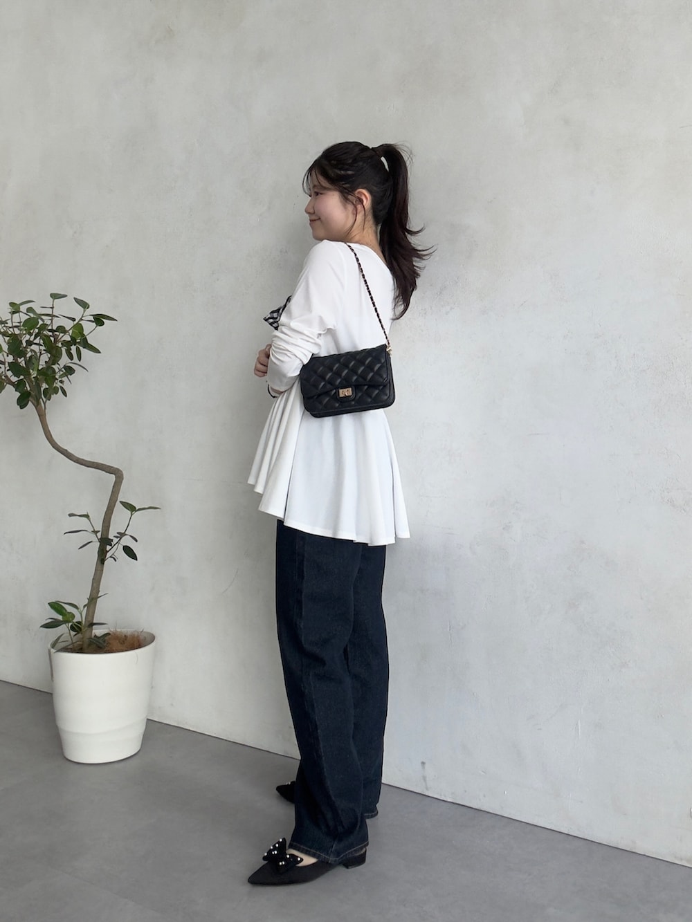 ブラック系のトートバッグ、ホワイト系のTシャツ/カットソーを着用したレディースの春コーディネートの2枚目の写真