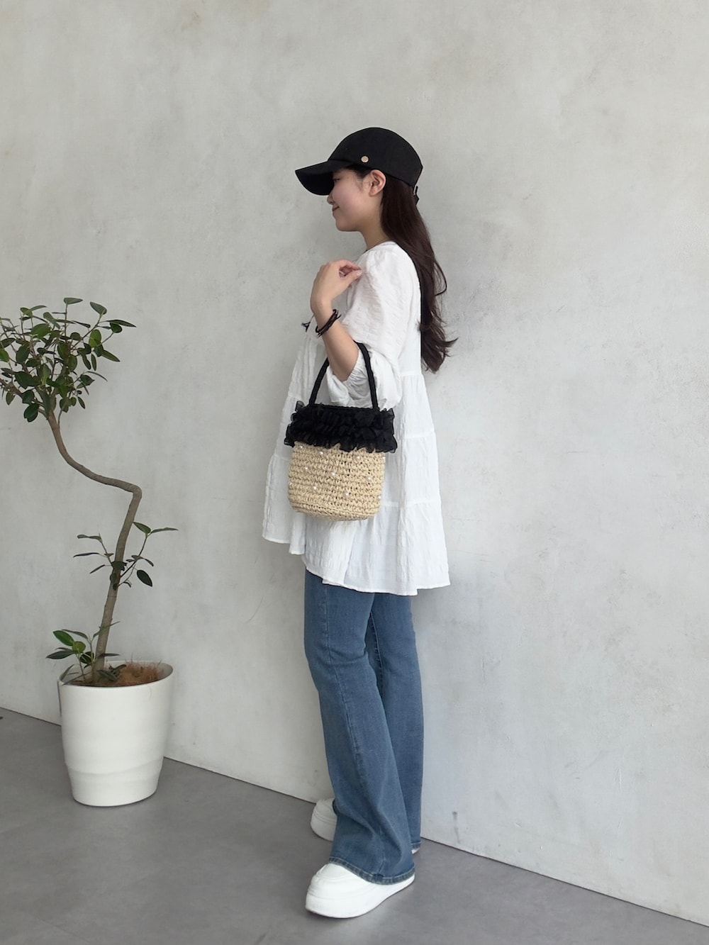 ブルー系のデニムパンツ、ホワイト系のスニーカー、ホワイト系のシャツ/ブラウスを着用したレディースの春コーディネートの2枚目の写真