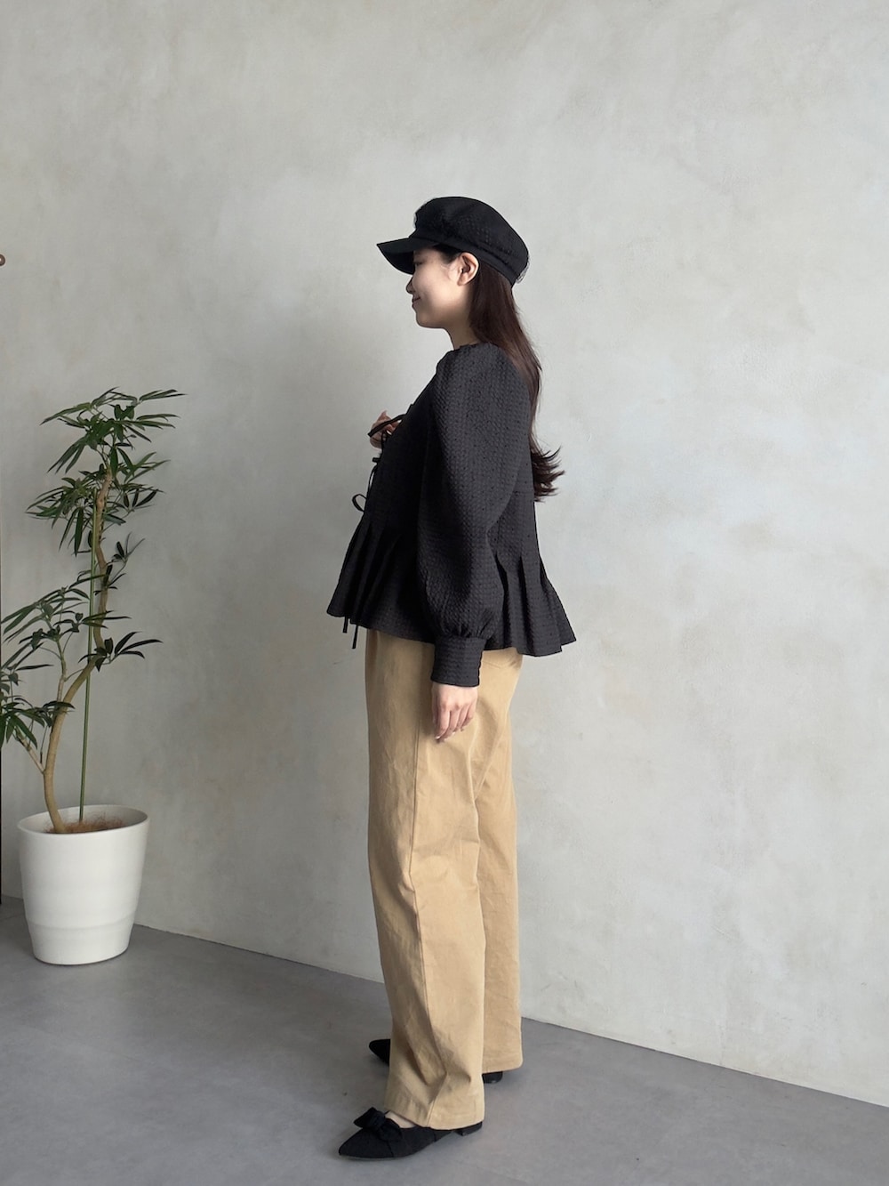 ベージュ系のチノパンツ、ブラック系のパンプス、ブラック系のシャツ/ブラウスを着用したレディースの春コーディネートの2枚目の写真