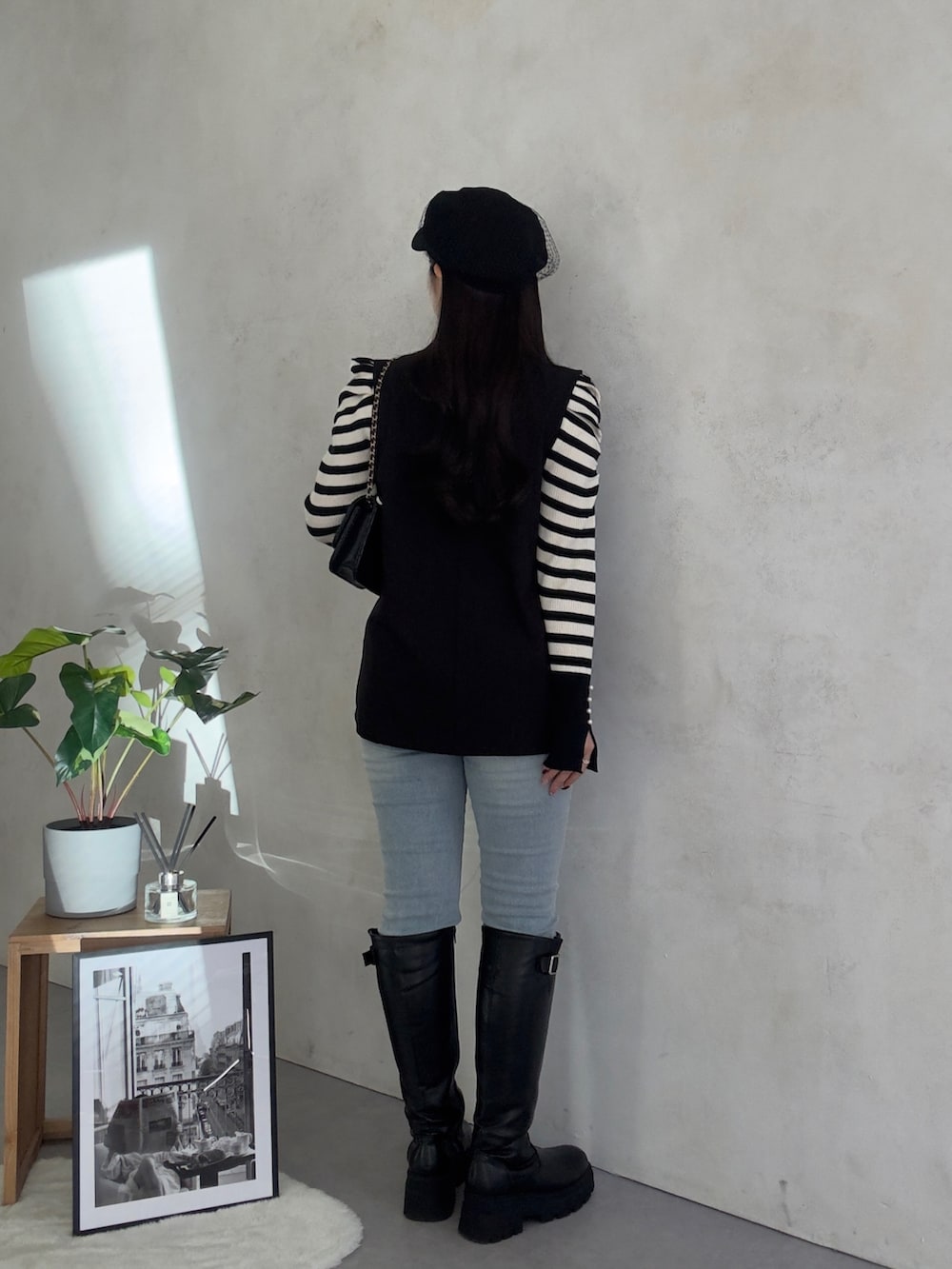 ブルー系のデニムパンツ、ブラック系のブーツ、ホワイト系のニット/セーターを着用したレディースの冬コーディネートの3枚目の写真