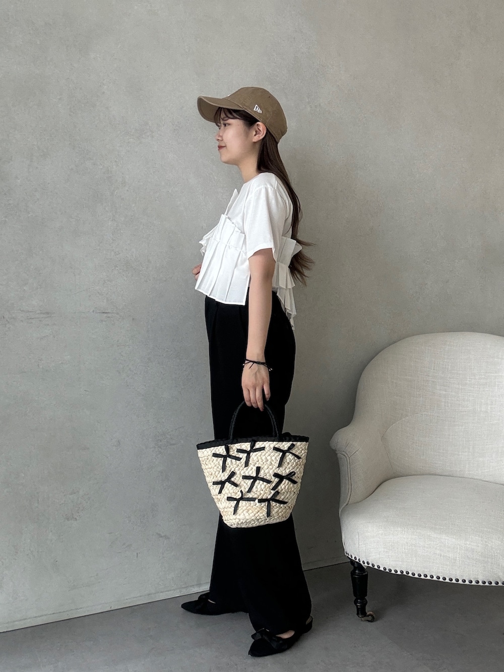 ブラック系のかごバッグ、ブラック系のスラックス、ブラック系のパンプスを着用したレディースの夏コーディネートの2枚目の写真