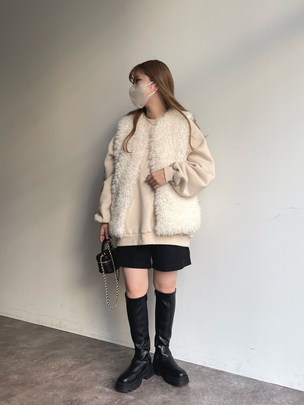 ホワイト系のスウェット、ホワイト系のベスト、ブラック系のその他パンツを着用したレディースの秋コーディネートの2枚目の写真