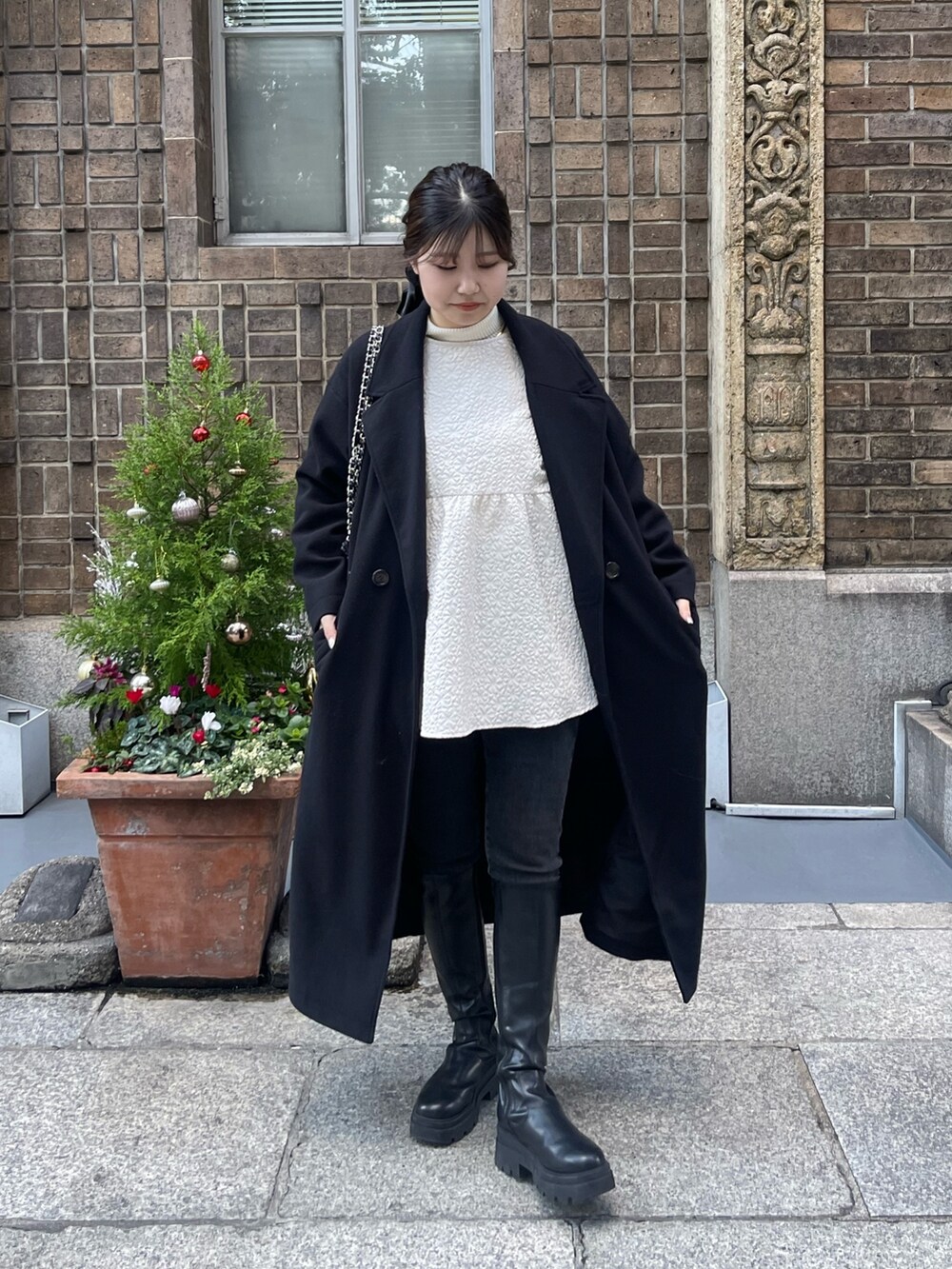 ホワイト系のニット/セーター、ホワイト系のシャツ/ブラウス、ブラック系のショルダーバッグを着用したレディースの冬コーディネートの3枚目の写真