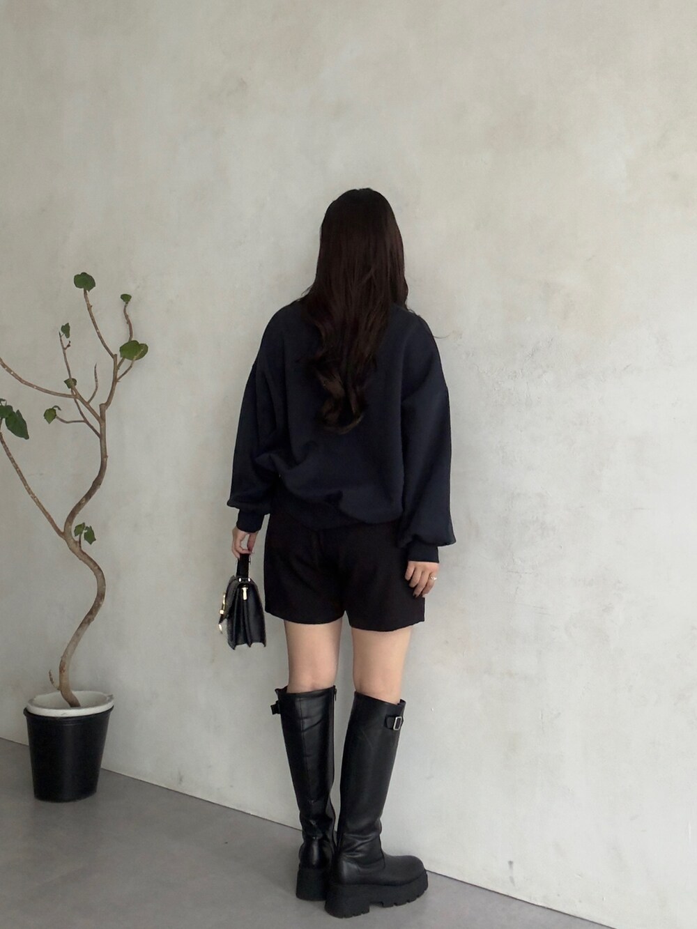 ブラック系のその他パンツ、ブラック系のブーツ、ブルー系のTシャツ/カットソーを着用したレディースの秋コーディネートの3枚目の写真