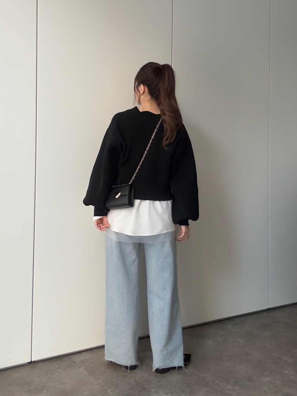 ブラック系のカーディガン/ボレロ、ホワイト系のTシャツ/カットソー、ブルー系のデニムパンツを着用したレディースの冬コーディネートの3枚目の写真