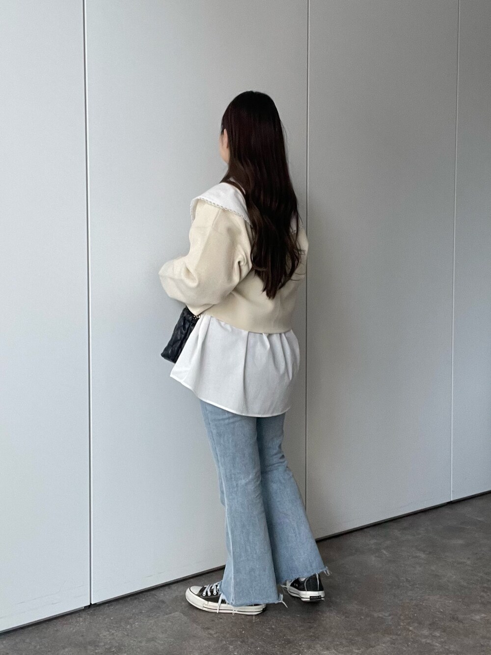 ホワイト系のシャツ/ブラウス、ホワイト系のカーディガン/ボレロ、ブラック系のショルダーバッグを着用したレディースの春コーディネートの2枚目の写真