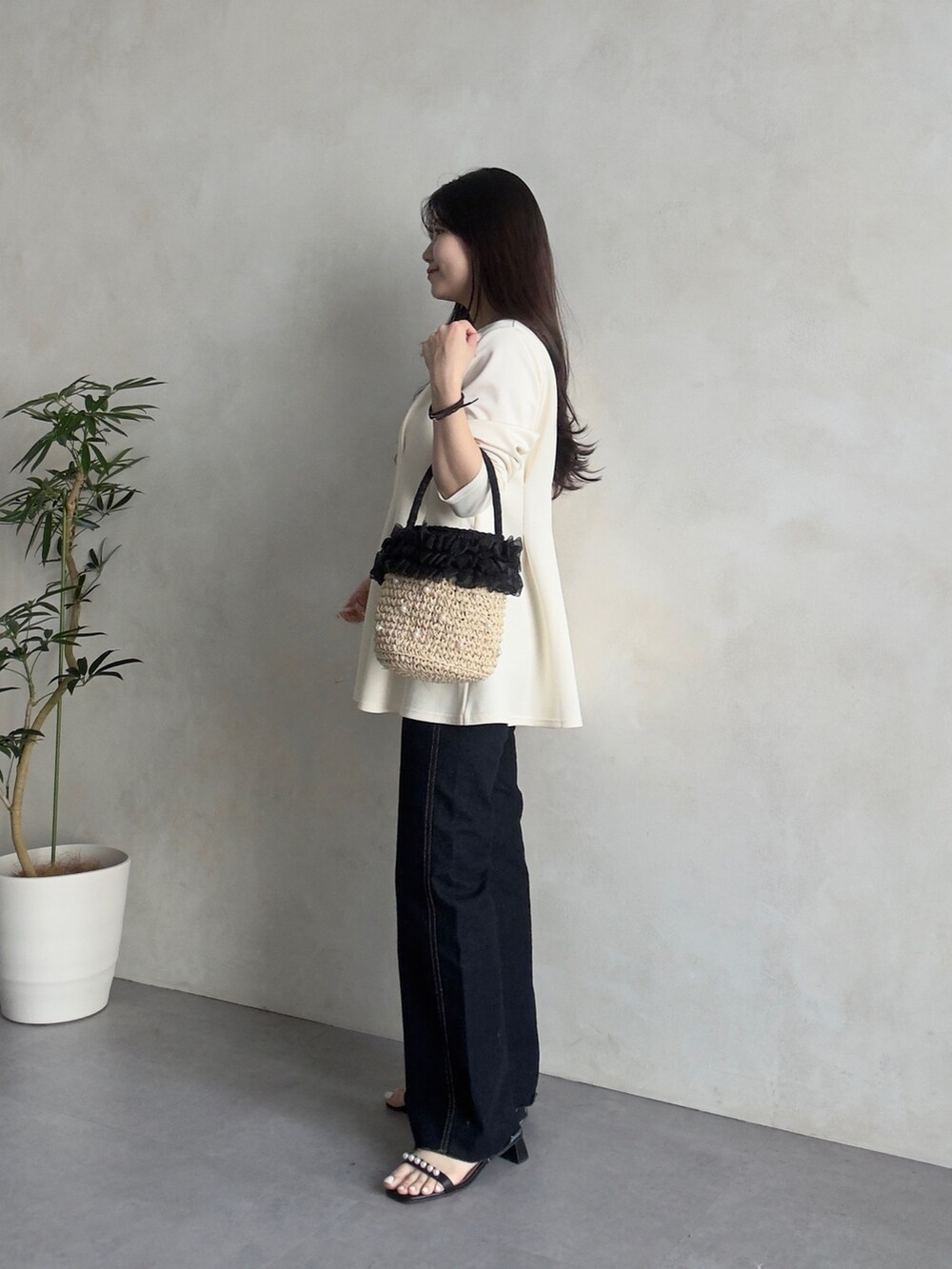 ブルー系のデニムパンツ、ブラック系のサンダル、ホワイト系のカーディガン/ボレロを着用したレディースの春コーディネートの2枚目の写真