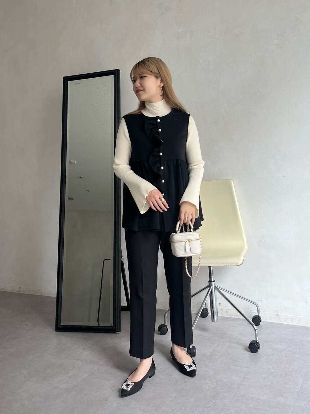 ブラック系のパンプス、ブラック系のその他パンツ、ホワイト系のショルダーバッグを着用したレディースの夏コーディネートの2枚目の写真