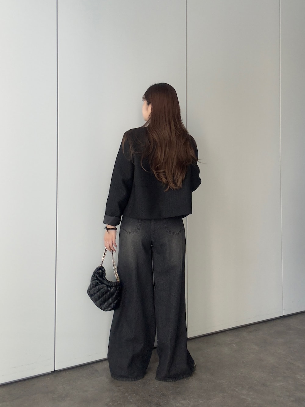 ブラック系のデニムパンツ、ブラック系のノーカラージャケット、ホワイト系のシャツ/ブラウスを着用したレディースの冬コーディネートの3枚目の写真