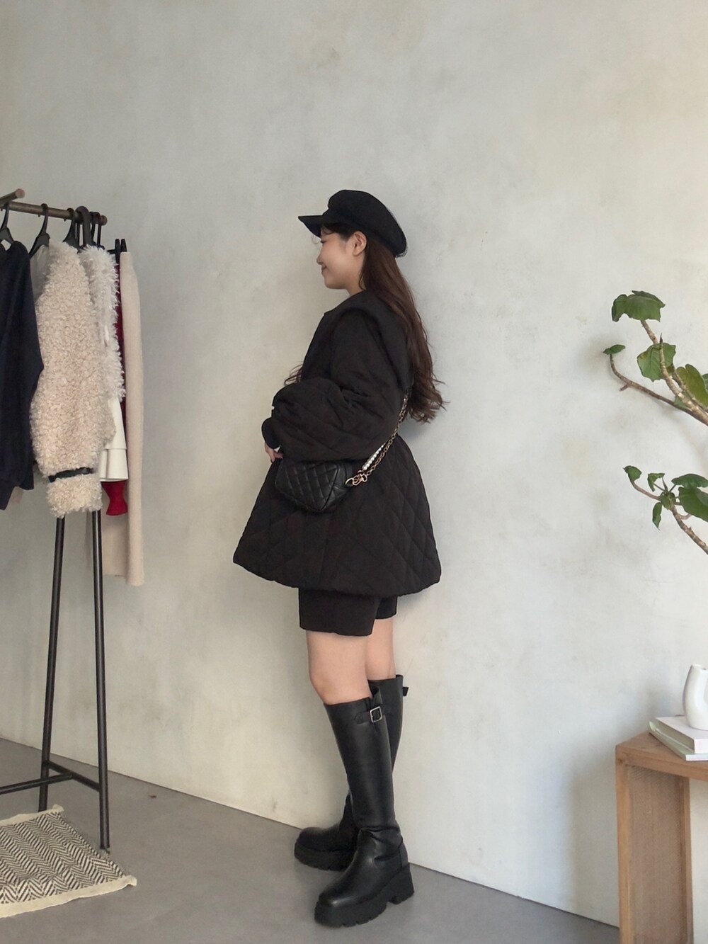 ホワイト系のニット/セーター、ブラック系のその他パンツ、ブラック系のブーツを着用したレディースの秋コーディネートの2枚目の写真