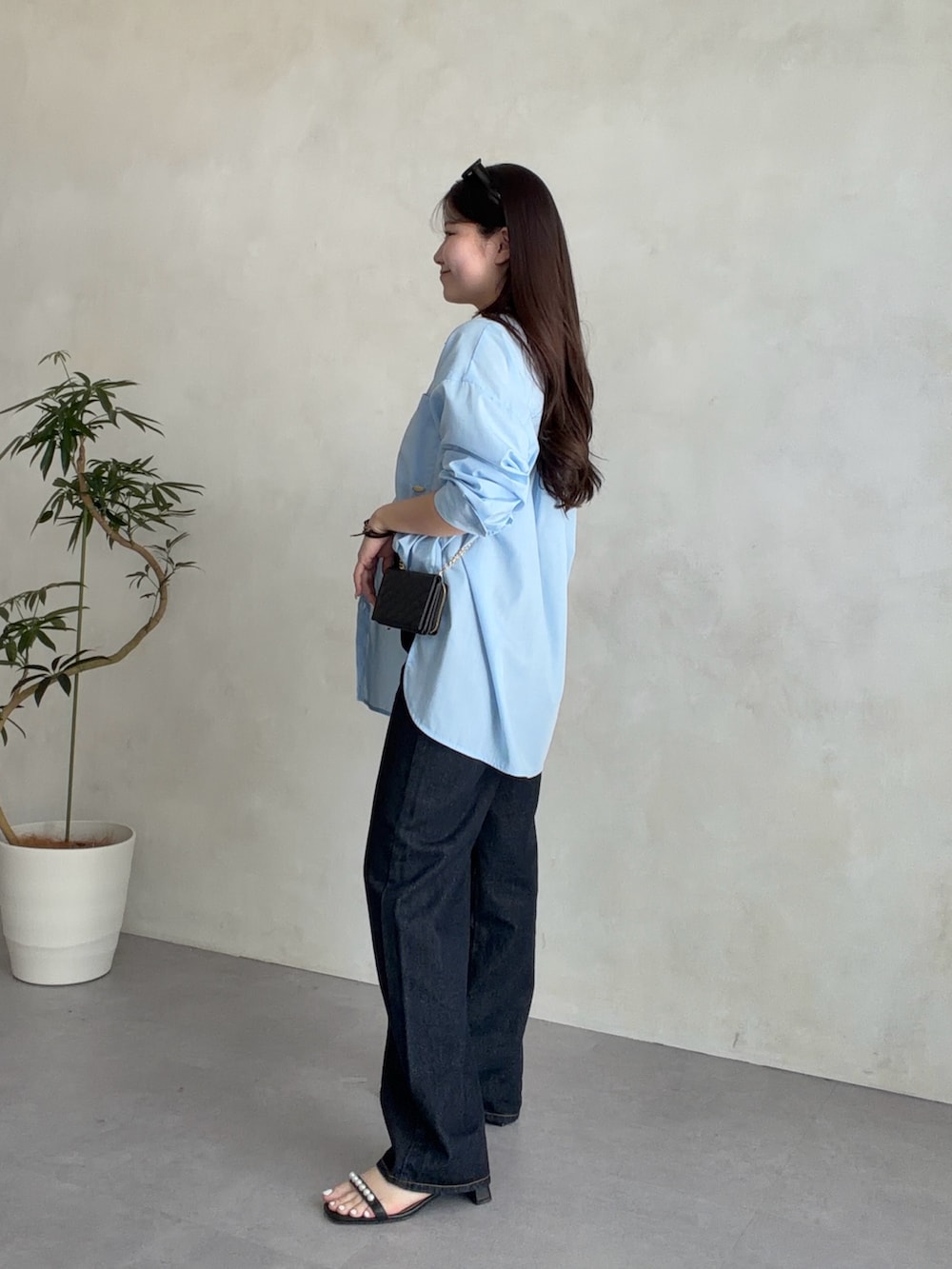 ブラック系のサンダル、ブルー系のシャツ/ブラウスを着用したレディースの春コーディネートの2枚目の写真