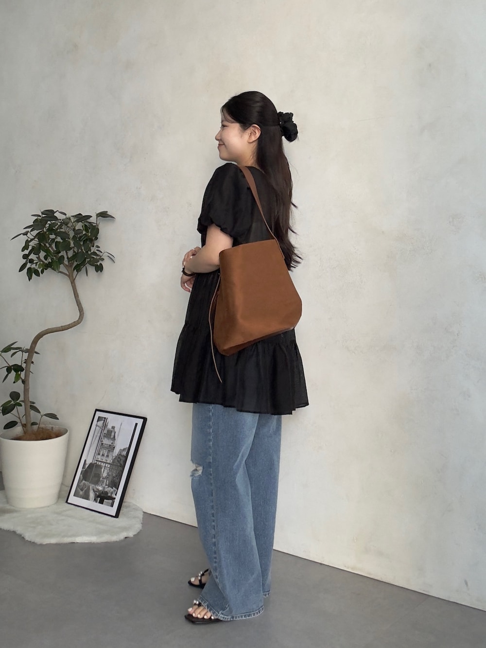 ブルー系のデニムパンツ、ブラック系のサンダル、ブラック系のシャツ/ブラウスを着用したレディースの夏コーディネートの2枚目の写真