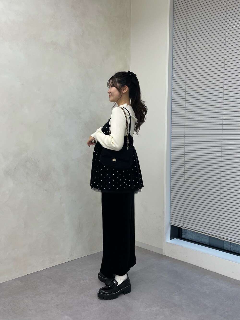 ホワイト系のニット/セーター、ブラック系のスカート、ブラック系のローファーを着用したレディースの秋コーディネートの2枚目の写真
