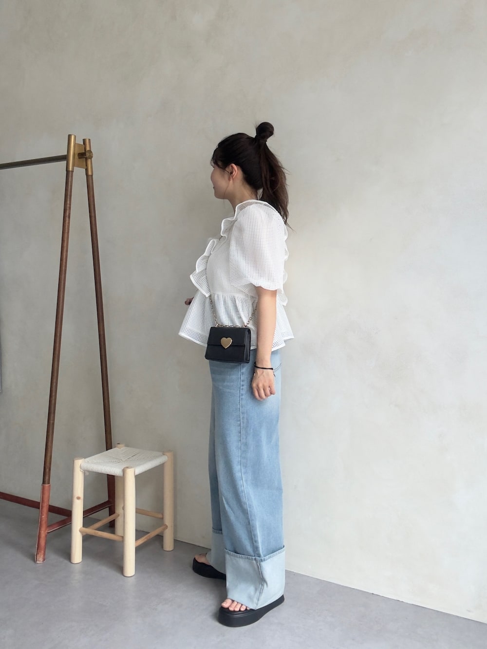 ホワイト系のシャツ/ブラウス、ブラック系のサンダル、ブルー系のデニムパンツを着用したレディースの春コーディネートの2枚目の写真