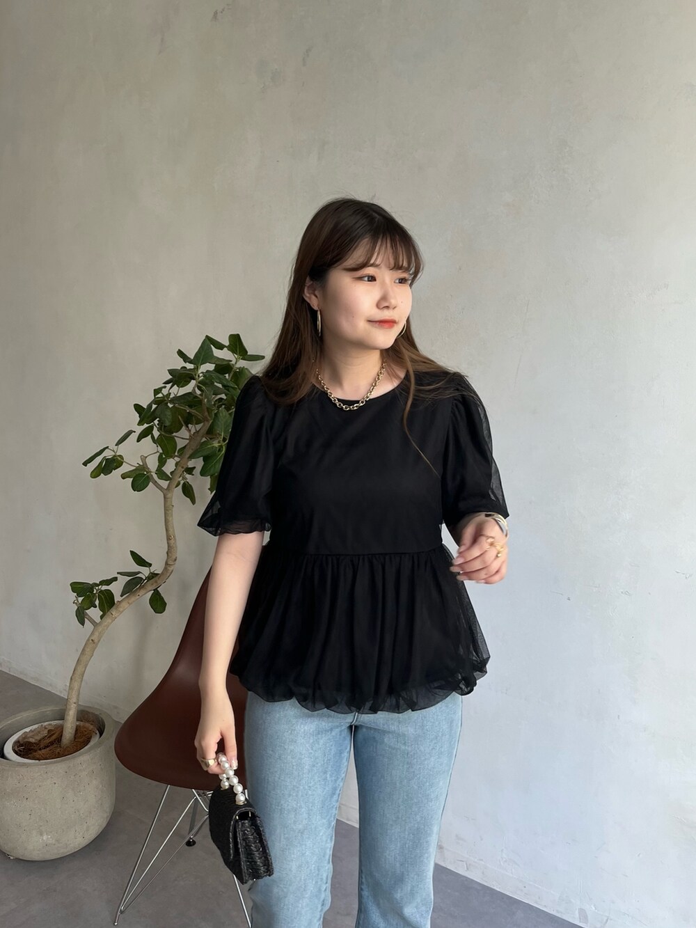 ブルー系のデニムパンツ、ブラック系のシャツ/ブラウス、ゴールド系のネックレスを着用したレディースの春コーディネートの2枚目の写真