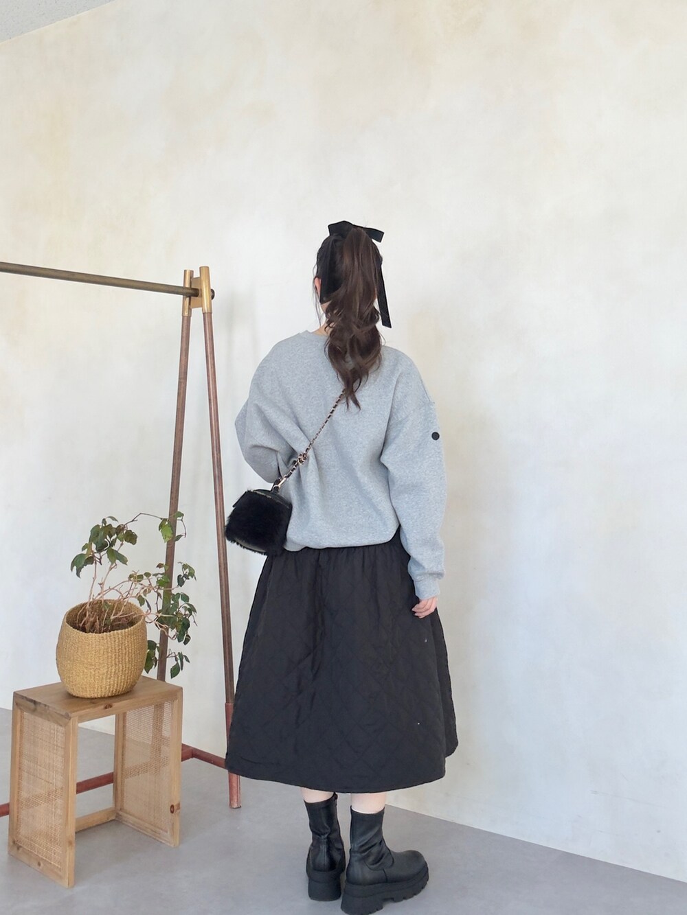 ブラック系のスカート、ブラック系のブーツ、グレー系のTシャツ/カットソーを着用したレディースの秋コーディネートの3枚目の写真