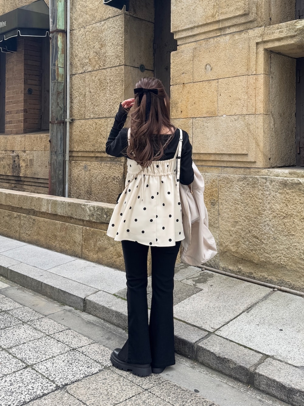 ブラック系のTシャツ/カットソー、ブラック系のショルダーバッグ、ホワイト系のキャミソールを着用したレディースの冬コーディネートの2枚目の写真