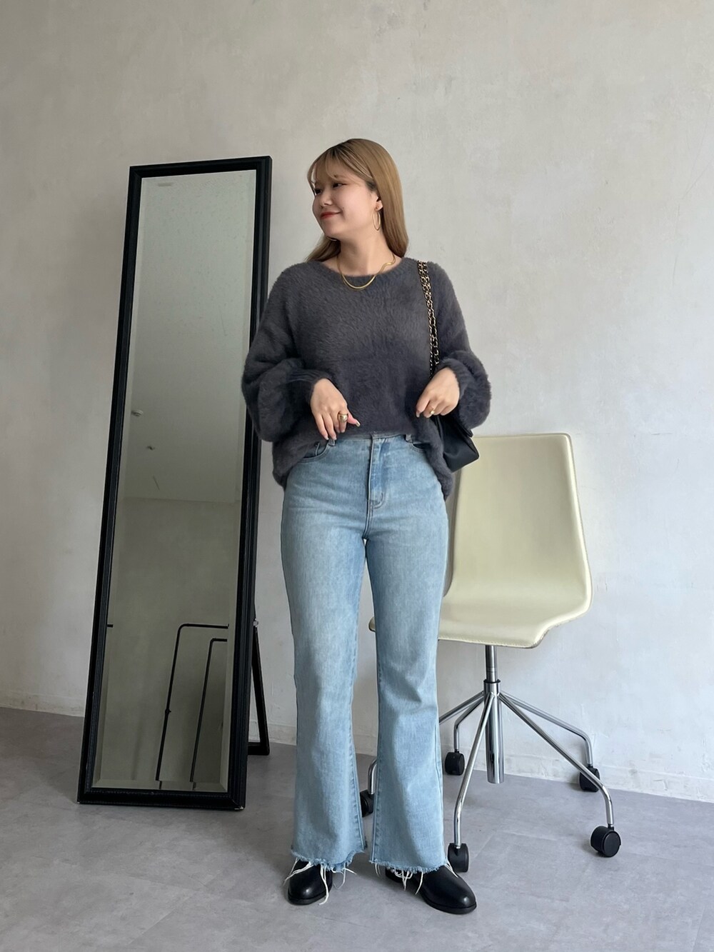 ブルー系のデニムパンツ、グレー系のカーディガン/ボレロ、ゴールド系のネックレスを着用したレディースの夏コーディネートの3枚目の写真