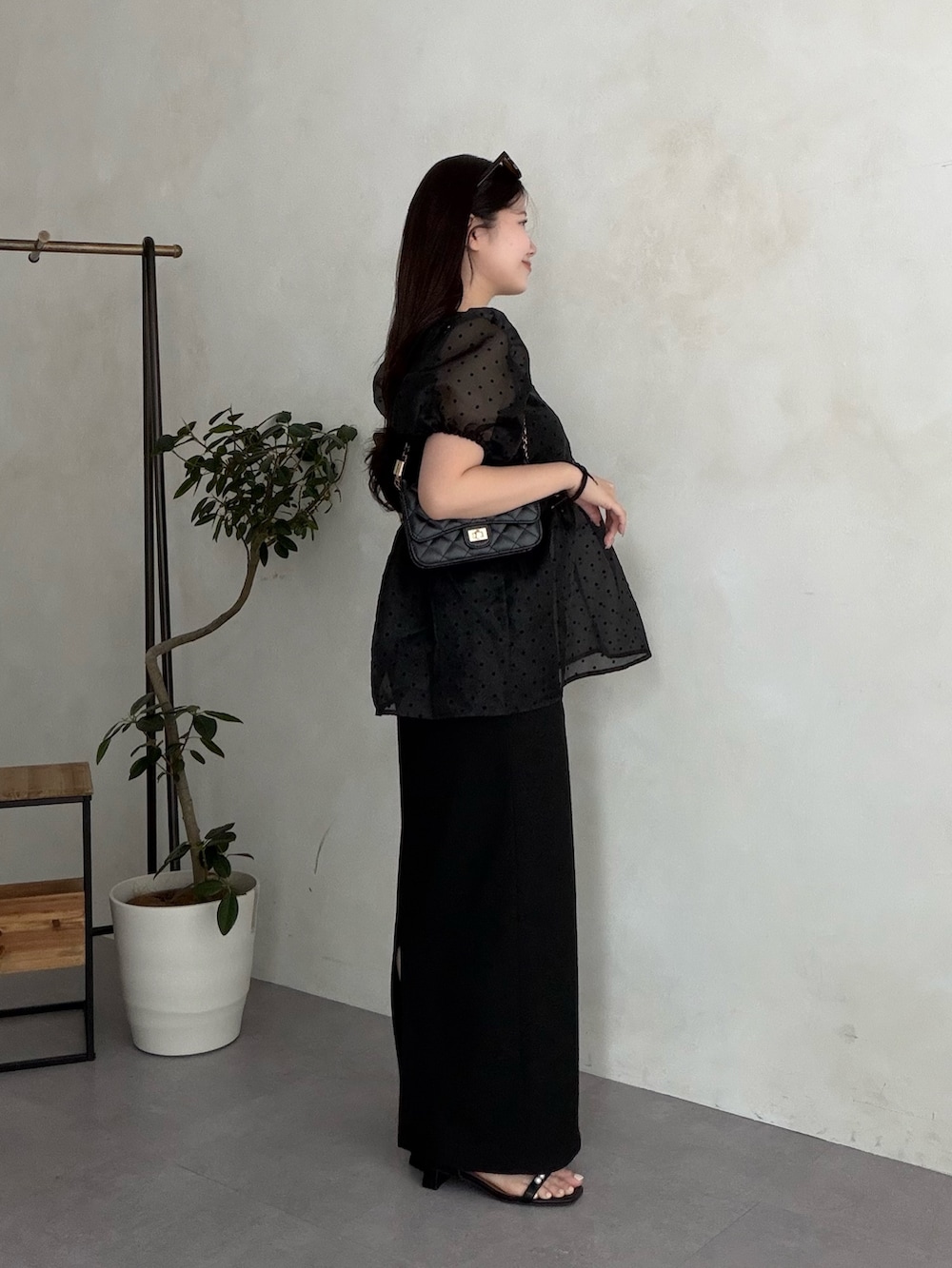 ブラック系のトートバッグ、ブラック系のスカート、ブラック系のサンダルを着用したレディースの夏コーディネートの2枚目の写真