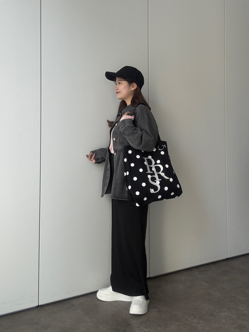 ブラック系のデニムジャケット、ピンク系のTシャツ/カットソー、ブラック系のトートバッグを着用したレディースの春コーディネートの2枚目の写真
