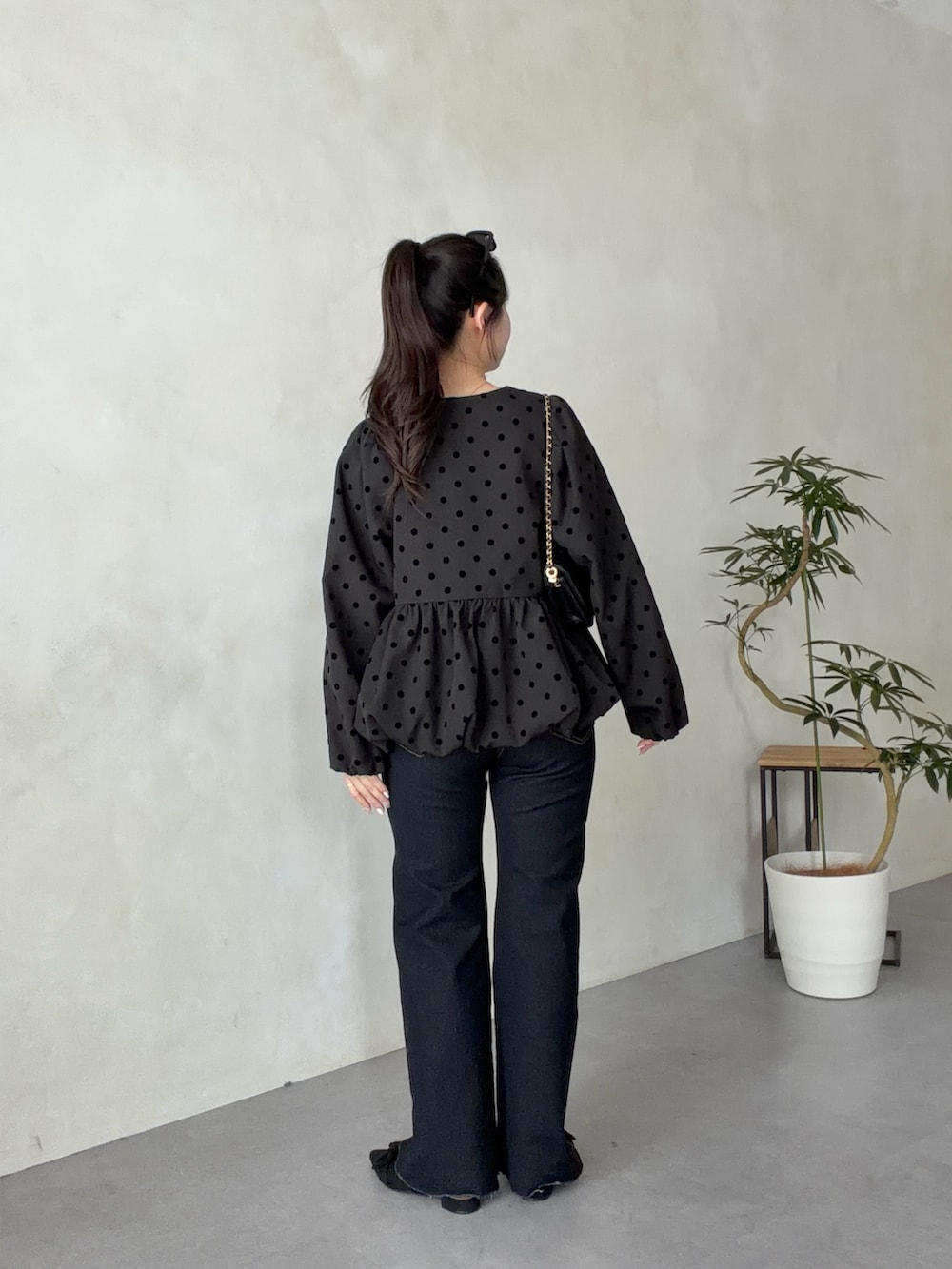 ブラック系のトートバッグ、ブルー系のデニムパンツ、ブラック系のパンプスを着用したレディースの春コーディネートの3枚目の写真