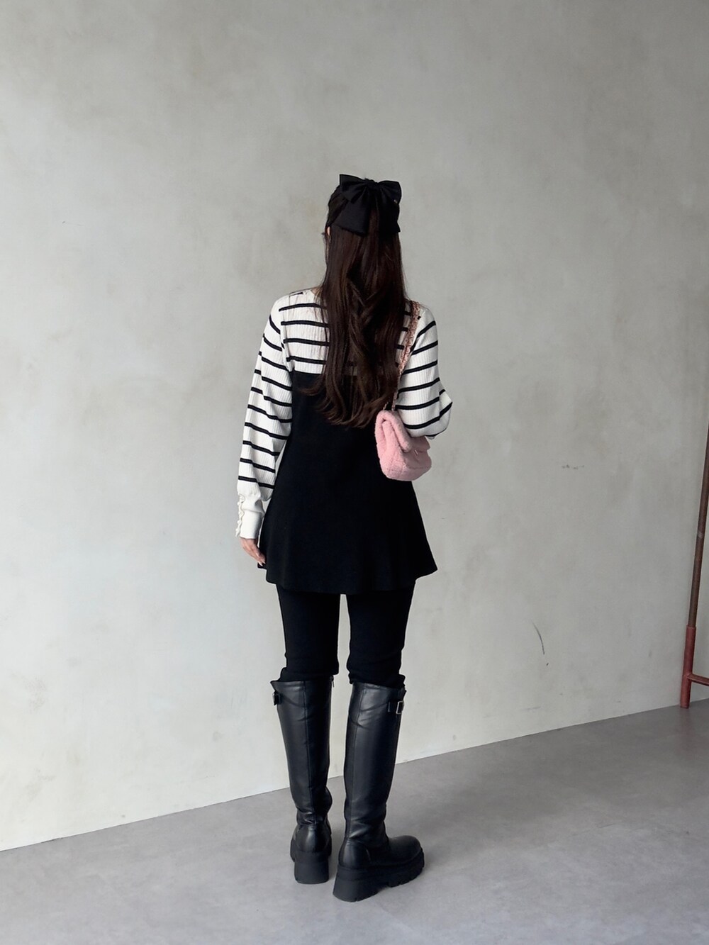 ブラック系のその他パンツ、ブラック系のブーツ、ホワイト系のニット/セーターを着用したレディースの秋コーディネートの2枚目の写真