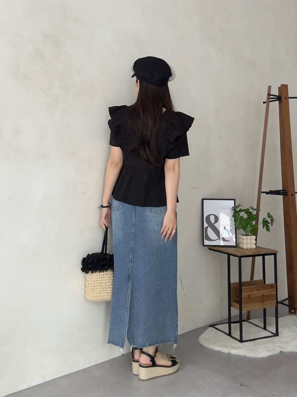 ベージュ系のかごバッグ、ブルー系のスカート、ブラック系のサンダルを着用したレディースの夏コーディネートの3枚目の写真