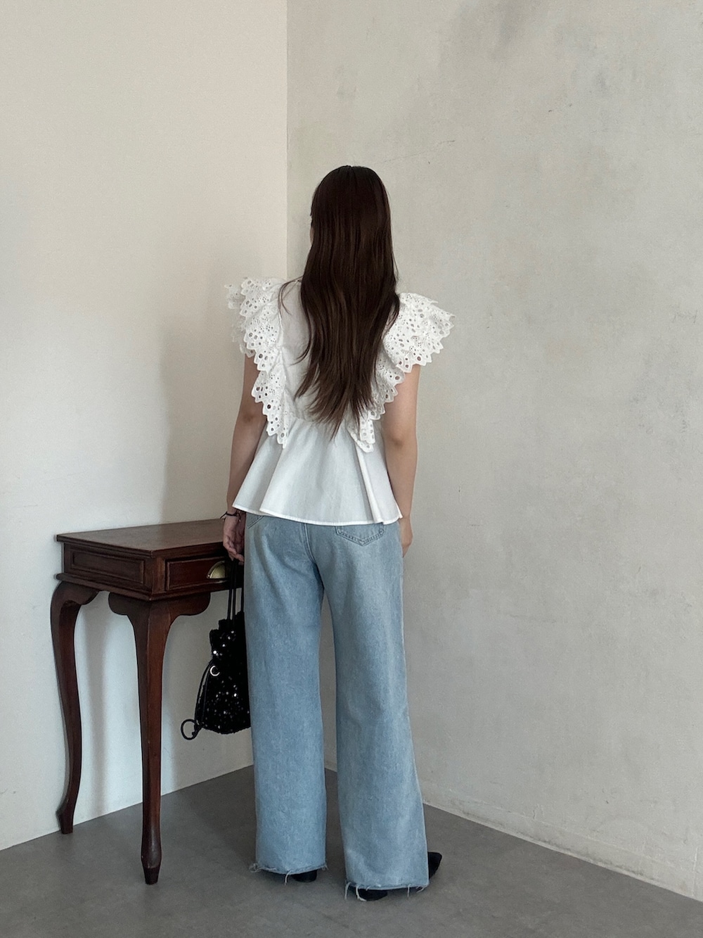 ホワイト系のシャツ/ブラウス、ブルー系のデニムパンツ、ブラック系のショルダーバッグを着用したレディースの夏コーディネートの3枚目の写真