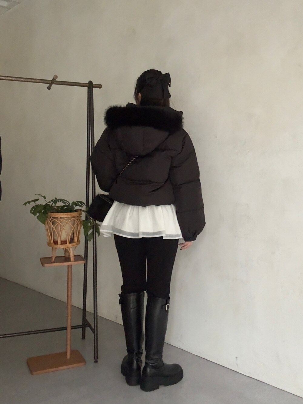 ブラック系のダウンジャケット/コート、ホワイト系のニット/セーター、ブラック系のその他パンツを着用したレディースの秋コーディネートの3枚目の写真