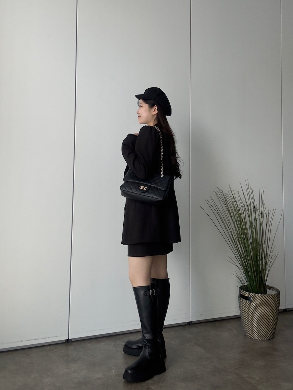 ブラック系のテーラードジャケット、ブラック系のニット/セーター、ブラック系のスカートを着用したレディースの秋コーディネートの2枚目の写真