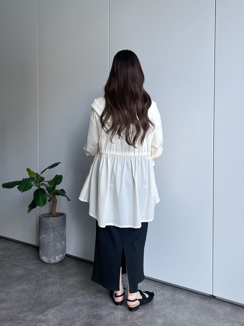 ホワイト系のTシャツ/カットソー、ホワイト系のマウンテンパーカー、ブラック系のスカートを着用したレディースの春コーディネートの3枚目の写真
