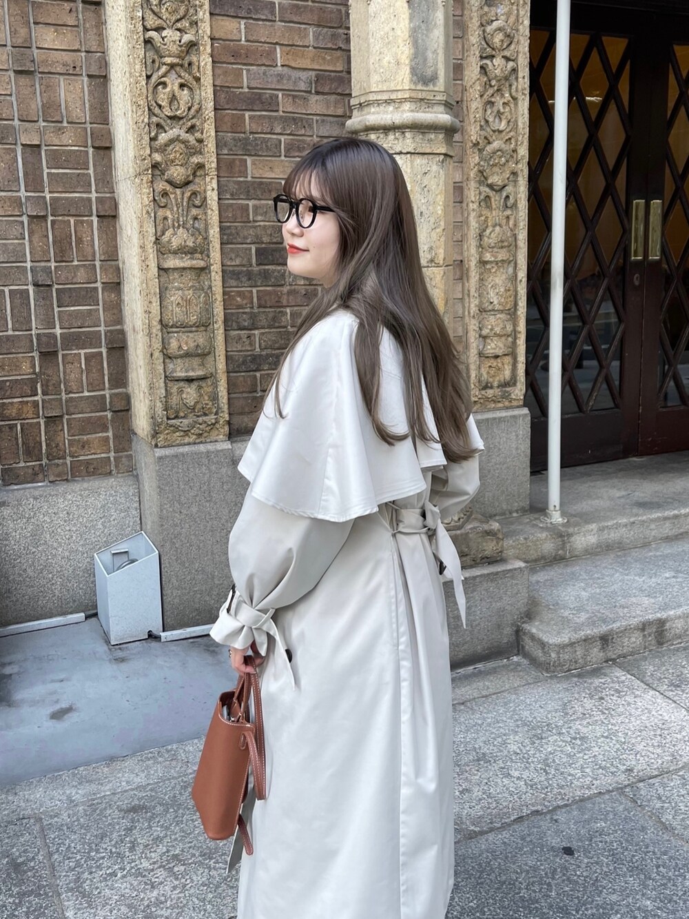 ホワイト系のシャツ/ブラウス、ベージュ系のトレンチコートを着用したレディースの冬コーディネートの2枚目の写真