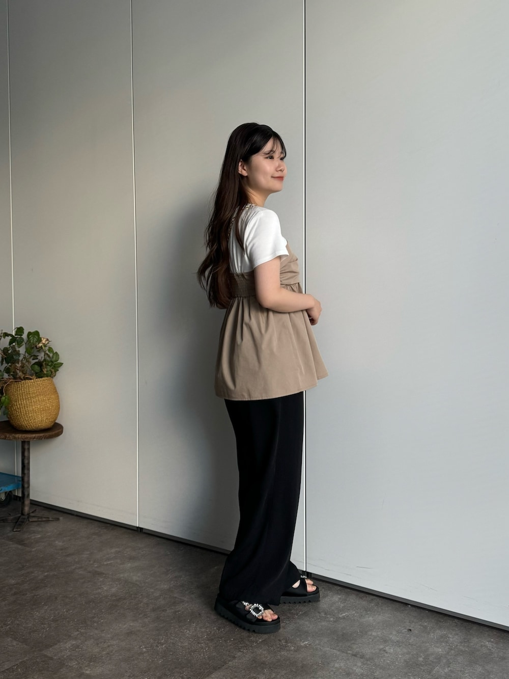 ブラック系のスラックス、ブラック系のショルダーバッグ、ホワイト系のTシャツ/カットソーを着用したレディースの春コーディネートの3枚目の写真