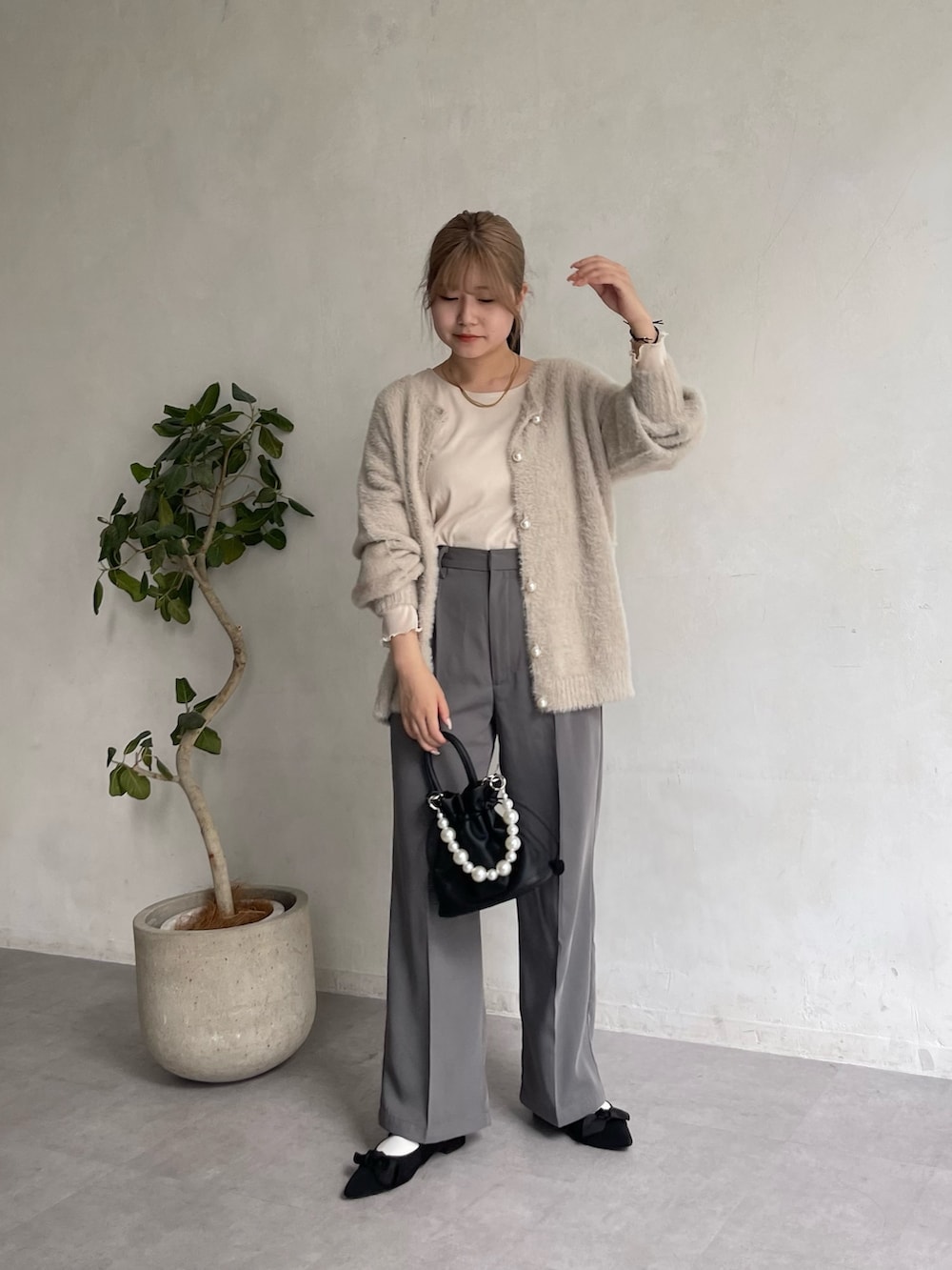 グレー系のスラックス、ブラック系のショルダーバッグ、ブラック系のパンプスを着用したレディースの夏コーディネートの3枚目の写真