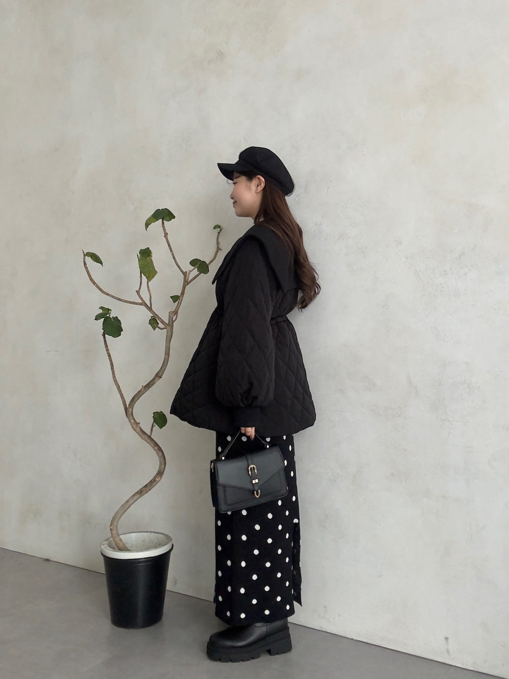 ホワイト系のニット/セーター、ブラック系のスカート、ブラック系のブーツを着用したレディースの秋コーディネートの2枚目の写真