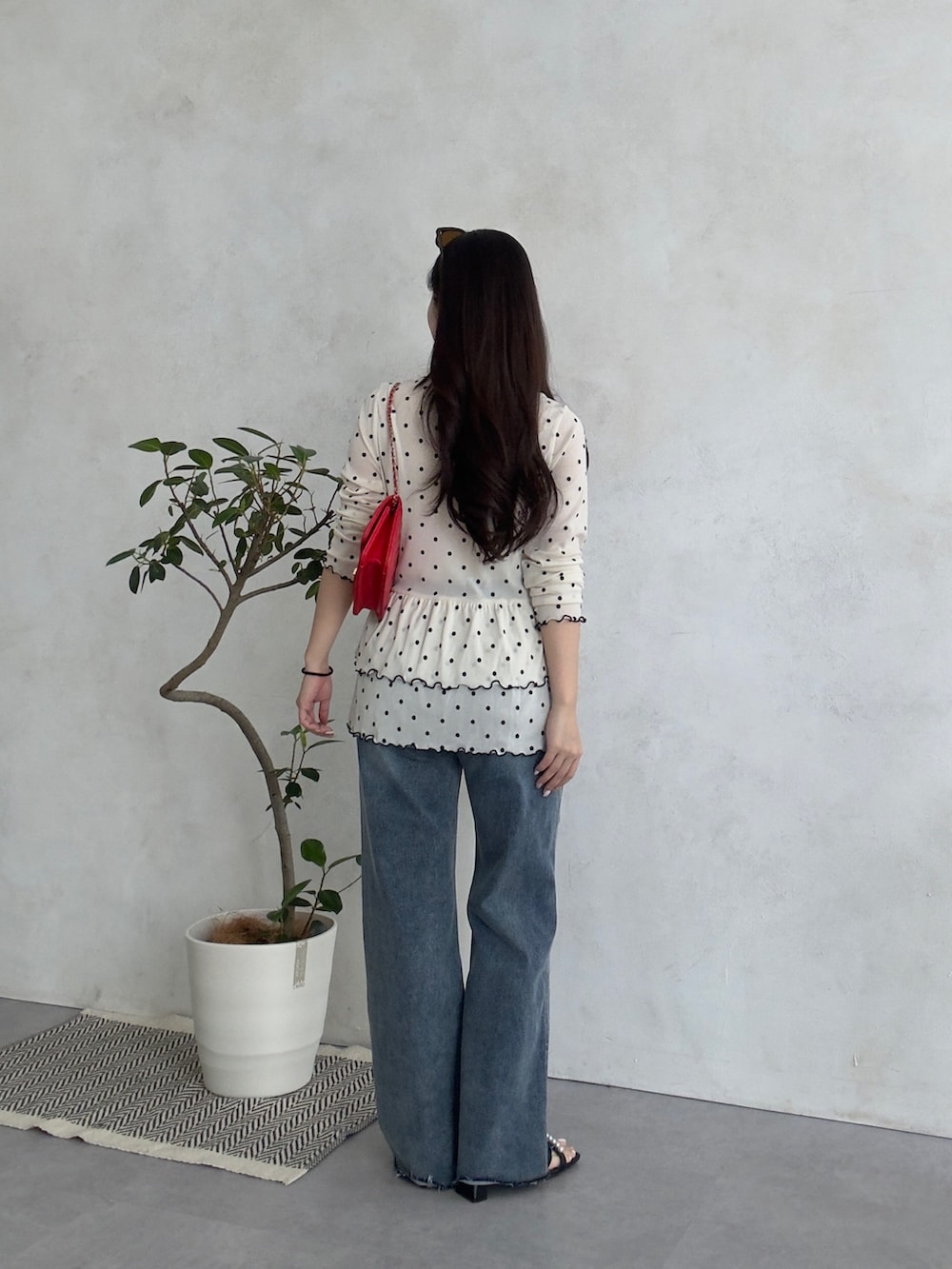 ホワイト系のTシャツ/カットソー、ブルー系のデニムパンツ、レッド系のトートバッグを着用したレディースの春コーディネートの3枚目の写真