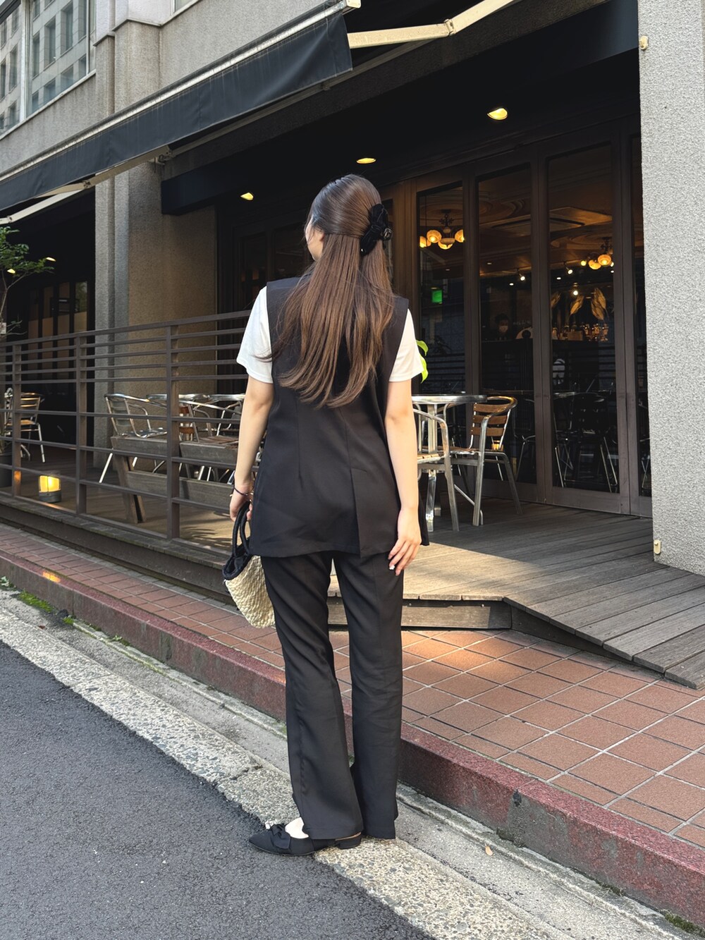 ホワイト系のTシャツ/カットソー、ブラック系のベスト、ブラック系のかごバッグを着用したレディースの夏コーディネートの2枚目の写真