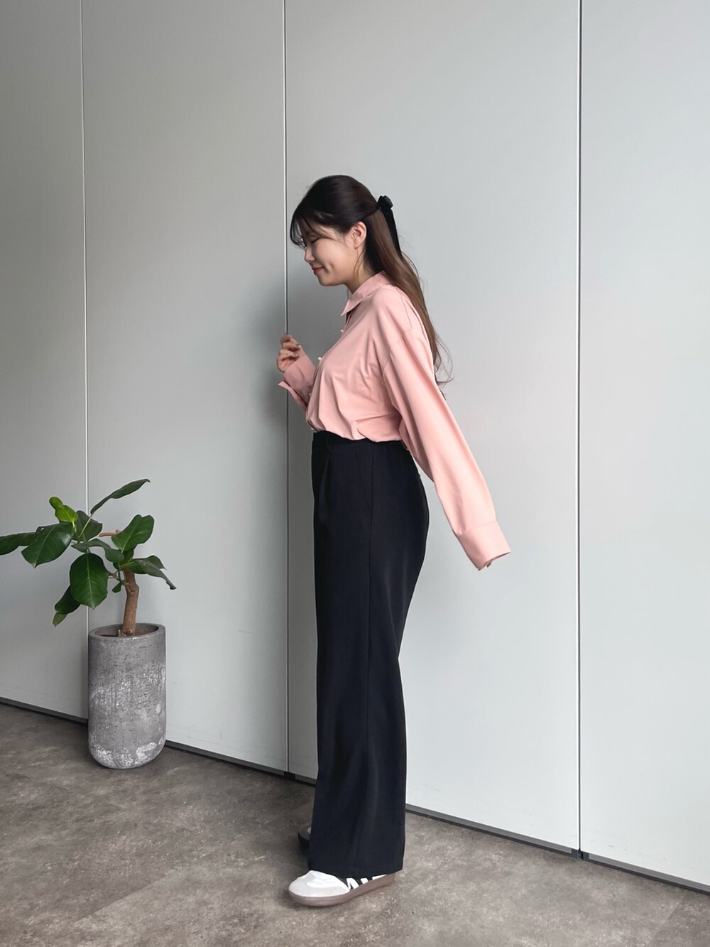 ブラック系のショルダーバッグ、ブラック系のスラックス、ホワイト系のスニーカーを着用したレディースの春コーディネートの2枚目の写真