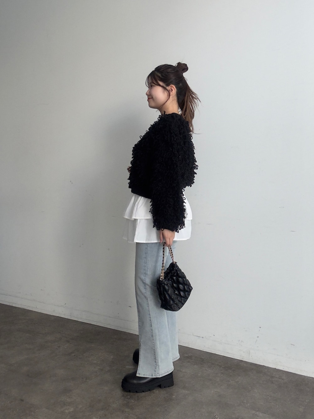 ブラック系のカーディガン/ボレロ、ホワイト系のスカート、ブルー系のデニムパンツを着用したレディースの夏コーディネートの2枚目の写真