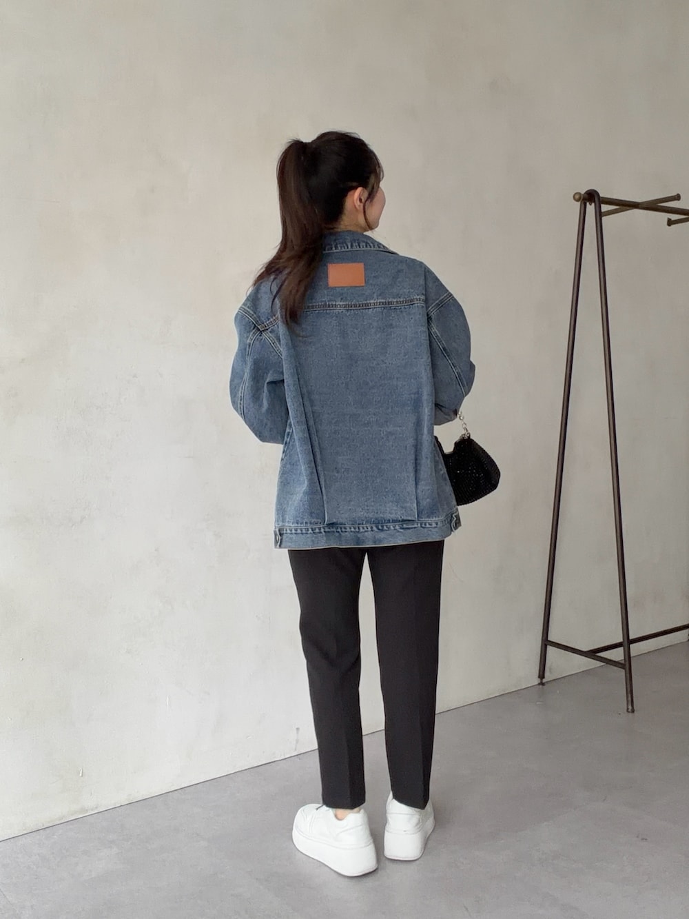 ブルー系のデニムジャケット、ブラック系のその他パンツ、ホワイト系のTシャツ/カットソーを着用したレディースの春コーディネートの3枚目の写真