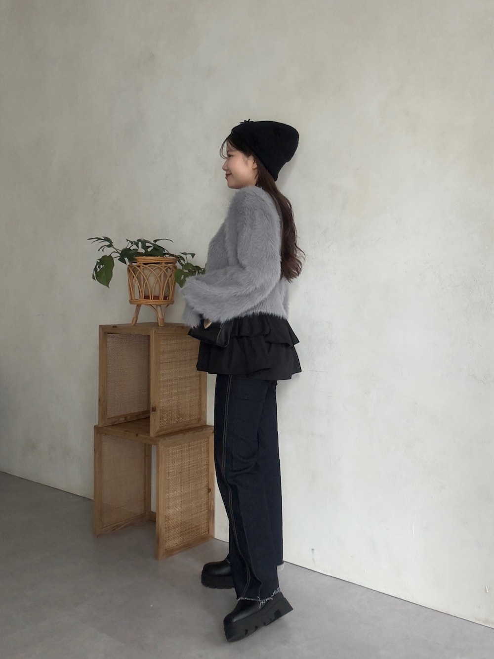 グレー系のカーディガン/ボレロ、ブラック系のスカート、ブルー系のデニムパンツを着用したレディースの秋コーディネートの2枚目の写真