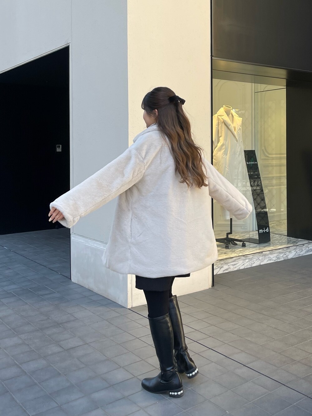 グレー系のニット/セーター、ブラック系のその他パンツ、ブラック系のブーツを着用したレディースの冬コーディネートの4枚目の写真