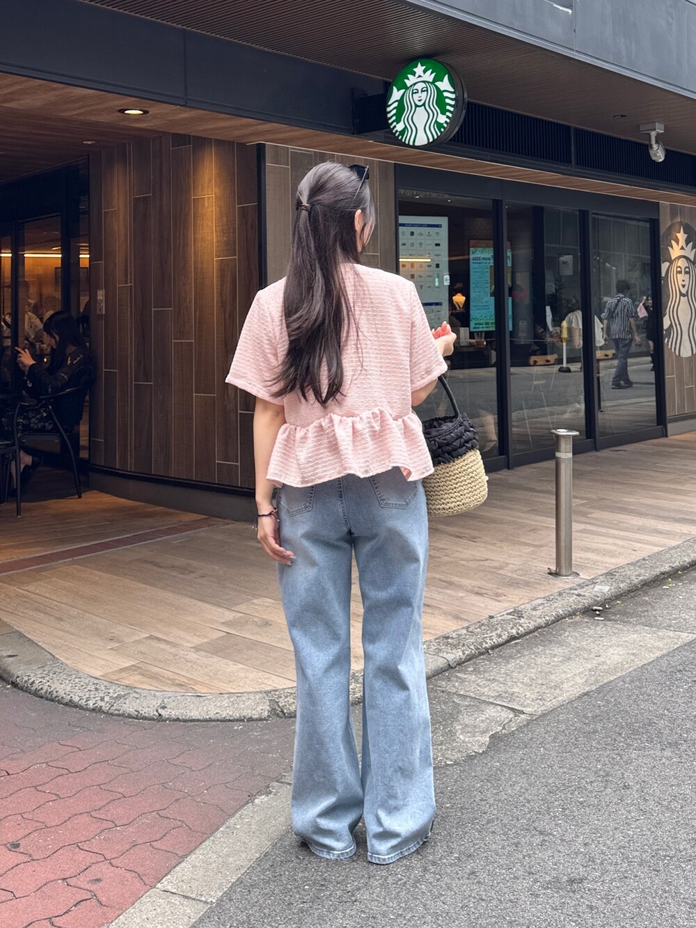 ピンク系のシャツ/ブラウス、ベージュ系のかごバッグ、ブラック系のサンダルを着用したレディースの夏コーディネートの3枚目の写真