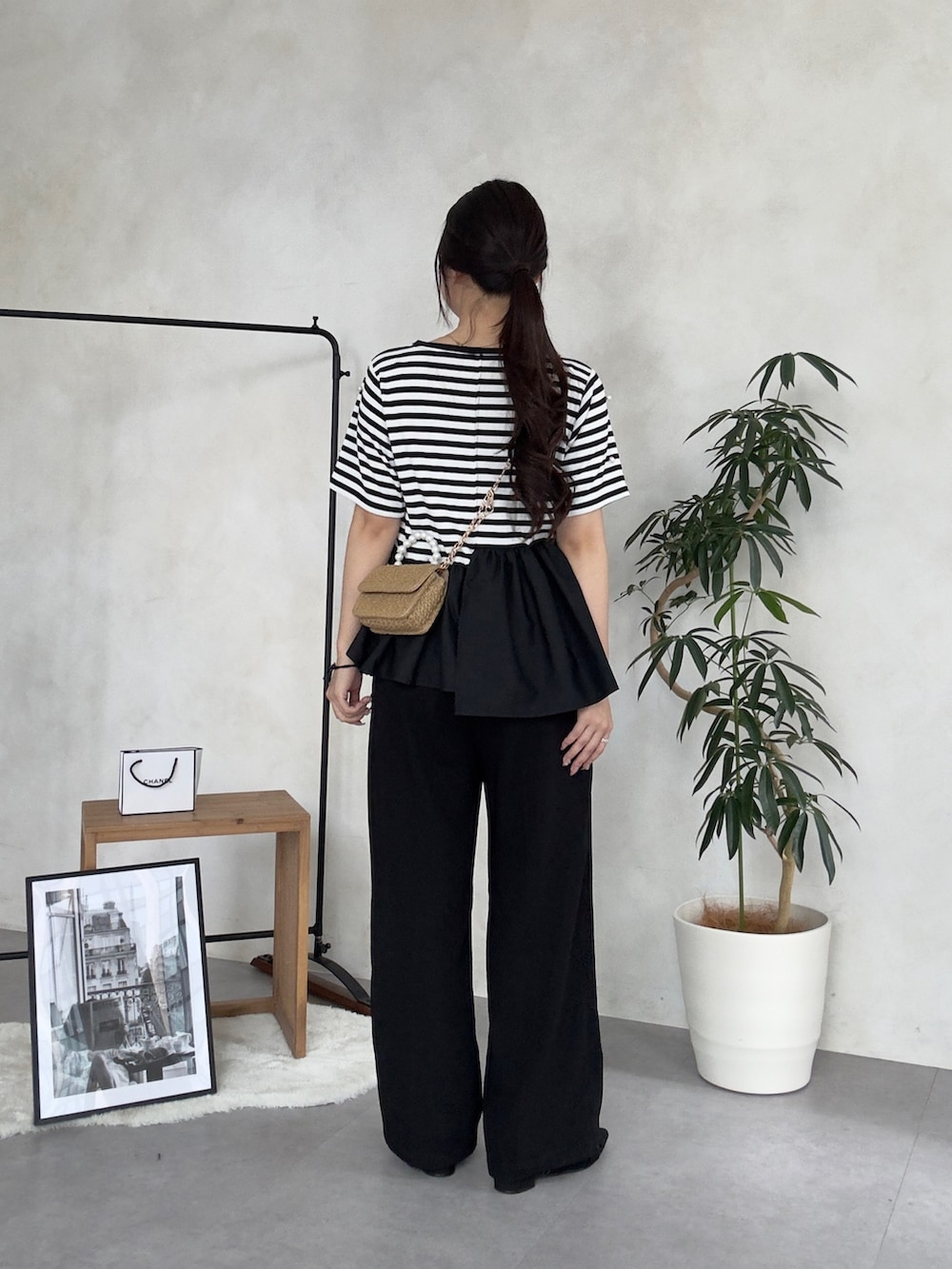 ブラック系のスラックス、ブラック系のパンプス、ブラック系のTシャツ/カットソーを着用したレディースの夏コーディネートの3枚目の写真