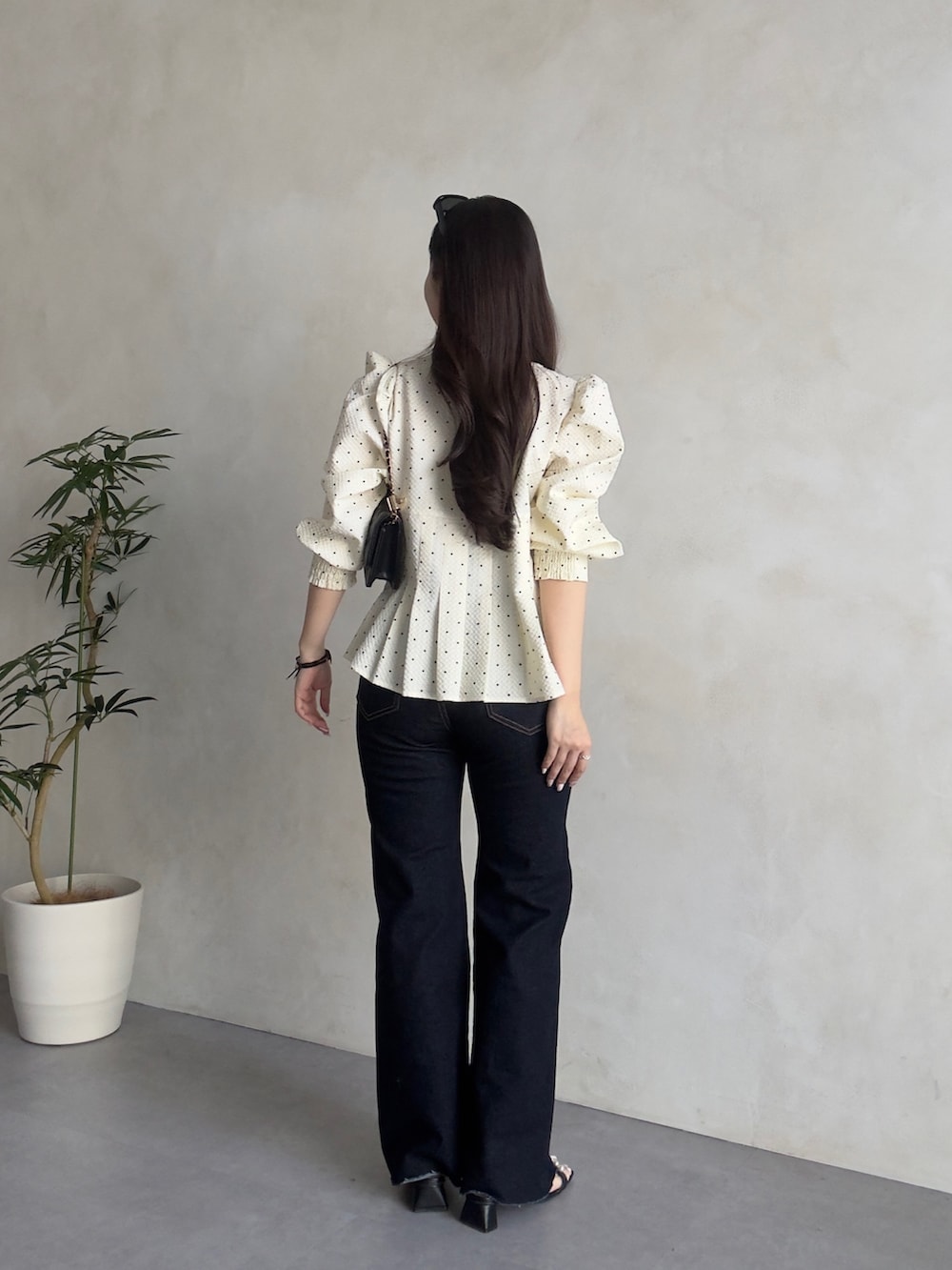 ブラック系のトートバッグ、ブルー系のデニムパンツ、ブラック系のサンダルを着用したレディースの春コーディネートの3枚目の写真