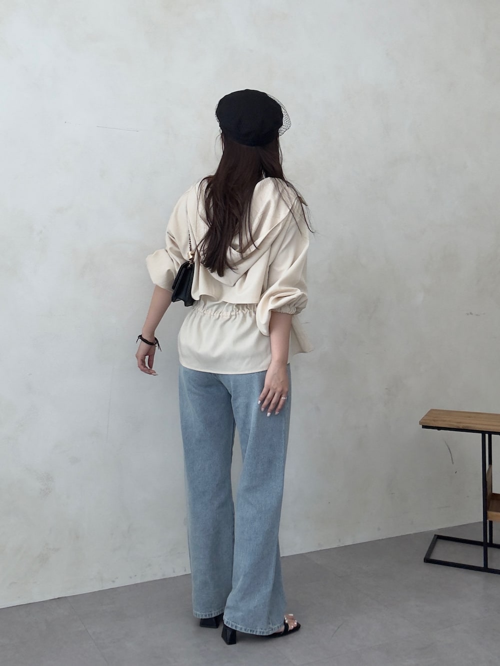 ブラック系のトートバッグ、ブラック系のサンダル、ホワイト系のブルゾンを着用したレディースの春コーディネートの3枚目の写真