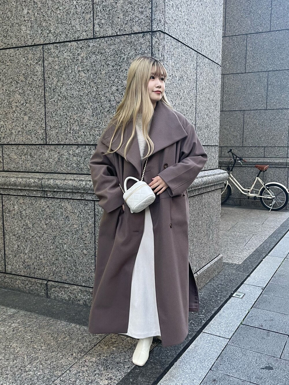 ベージュ系のカーディガン/ボレロ、ブラウン系のその他アウター、ホワイト系のスカートを着用したレディースの秋コーディネートの2枚目の写真