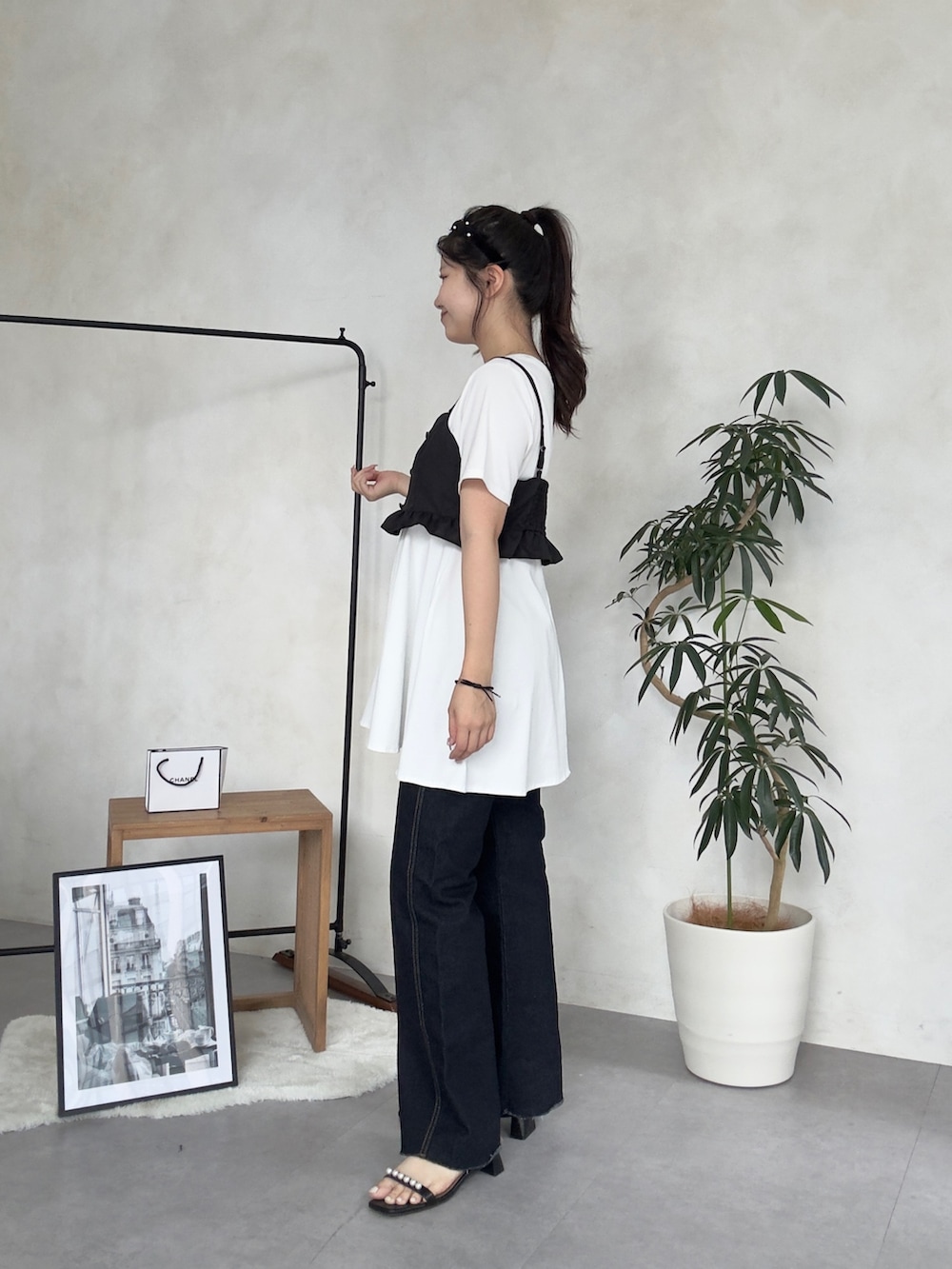 ベージュ系のかごバッグ、ブルー系のデニムパンツ、ブラック系のサンダルを着用したレディースの夏コーディネートの2枚目の写真